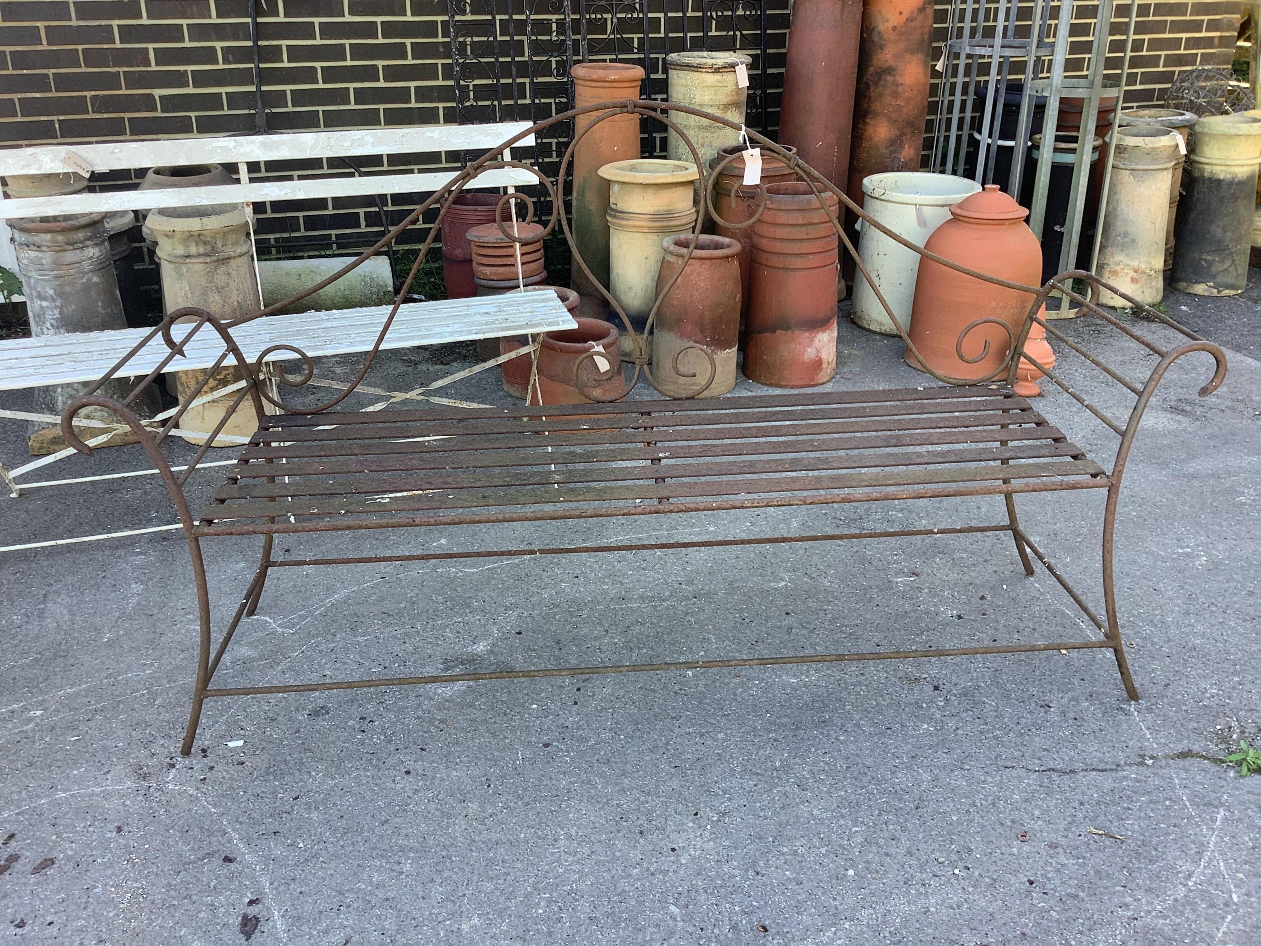 A pair of wrought iron garden benches, width 184cm, height 102cm. Condition - fair